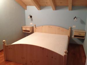 アンダロにあるAppartamento Family Parkのベッドルーム1室(木製ベッド1台、ナイトスタンド2台付)