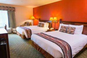 two beds in a hotel room with orange walls at Hualapai Lodge in Peach Springs