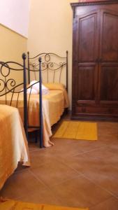 una camera con 2 letti e un armadio in legno di Le Due Cycas a Pantelleria