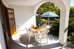 a table with chairs and an umbrella on a patio at Residence Capo San Marco & Renella in Sciacca +114 photos