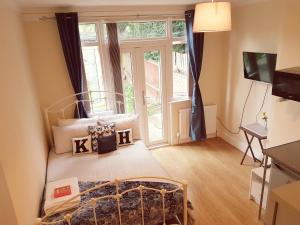 a bedroom with a bed and a large window at Kathleen House Plus in Enfield