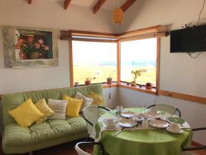 a living room with a green couch and a table at Las Hualas in Punta de Choros