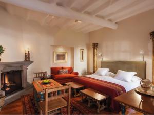 a bedroom with a bed and a fireplace at Inkaterra La Casona Relais & Chateaux in Cusco