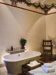 a bath tub in a bathroom with a chair at Inkaterra La Casona Relais & Chateaux in Cusco