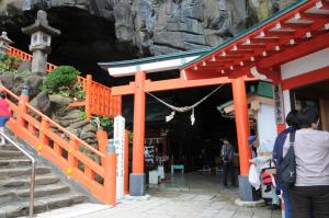 a woman is standing in front of a shrine at Guest House Aki in Nichinan