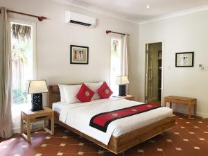 a bedroom with a large bed with red pillows at Peppercorn Beach Resort in Phú Quốc