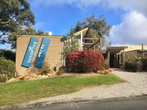 a building with a sign on the side of it at Sandpiper Motel Apollo Bay in Apollo Bay