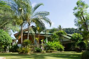 a house with palm trees in front of it at Jungle Village Bungalow in Ao Nang Beach