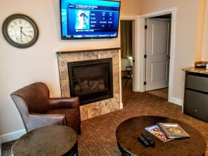 a living room with a fireplace and a flat screen tv at Resort at Eagle Point Golf Club Lodging in Medford