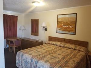 a hotel room with a bed and a desk at Sooner Motel in Stroud