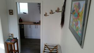 a hallway leading to a kitchen with a mirror at Mauao Studio in Mount Maunganui