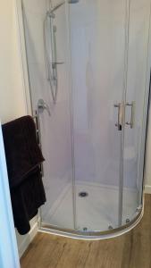 a shower with a glass door in a bathroom at Mauao Studio in Mount Maunganui