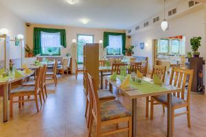 een eetkamer met houten tafels en stoelen bij Hotel am Galgenberg in Gera