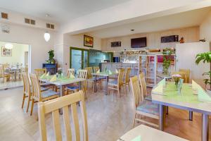 un restaurante con mesas y sillas y una cocina en Hotel am Galgenberg, en Gera