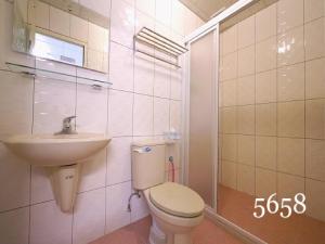東港的住宿－華僑的家，浴室配有卫生间、盥洗盆和淋浴。