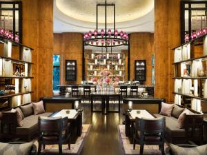 a restaurant with tables and chairs and a chandelier at AYANA Midplaza JAKARTA in Jakarta