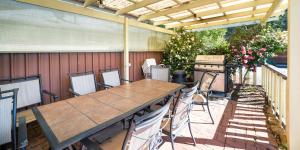 un patio con mesa, sillas y parrilla en Kookaburra Motor Lodge en Halls Gap