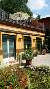 比利亞爾聖科斯坦佐的住宿－Casa Margherita，前面有鲜花的黄色房子