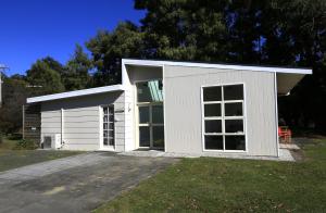 a small white garage with a large window at Riverwalk B&B in Robigana