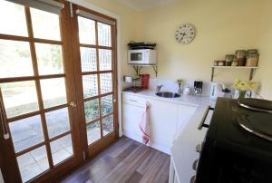 a kitchen with a sink and a clock on the wall at Riverwalk B&B in Robigana