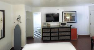 a living room with a tv and a dresser at Adara Palm Springs in Palm Springs