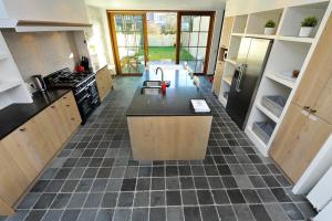 a large kitchen with a black counter top and appliances at Huize Ewoud in Bruges