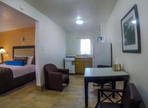 a small room with a bed and a desk and a kitchen at Adara Palm Springs in Palm Springs