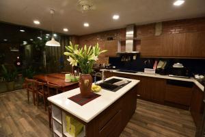 a kitchen with a table and a vase of flowers at Kiara's Home - Quiet Garden Villa in Hai Phong