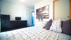 a bedroom with a bed with pillows and a tv at Le Clos Maric in Séné