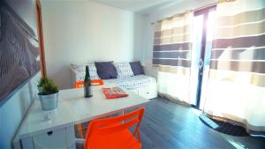 um quarto com uma mesa e cadeiras cor de laranja e um sofá em Le Clos Maric em Séné