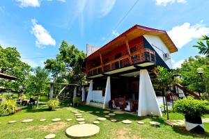 a house with a deck and a grass yard at Eco Hotel Black & White - Anuradhapura in Mihintale