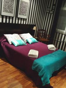 Una cama con almohadas azules y blancas. en Quarto privado Alentejo Litoral, en Grândola