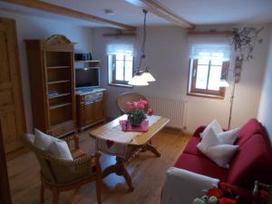 a living room with a red couch and a table at Ferienwohnung Hockert in Waltersdorf