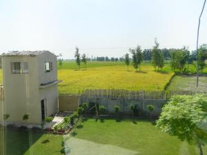 a yard with a house and a fence and a field at Farmers Villa in Amritsar