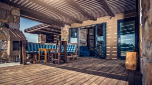 a wooden deck with a table and chairs on it at Keros Blue - Luxury in Wilderness in Kalliópi