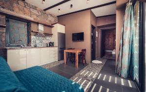a room with a bed and a kitchen with a table at Keros Blue - Luxury in Wilderness in Kalliópi