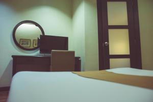 Un pat sau paturi într-o cameră la El Cielito Inn - Baguio