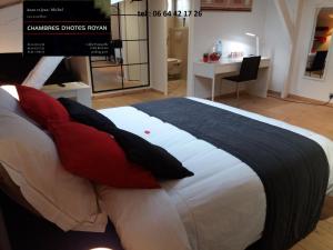 sypialnia z dużym łóżkiem z czerwonymi poduszkami w obiekcie Chambres d'Hôtes LA PASTOURELLE Royan centre w mieście Royan