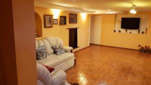 a living room with a white couch and a television at Ezerkiemis in Trakai