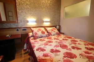 um quarto com uma cama com colcha floral em Hostal Hispano - Argentino Gran Vía em Madri