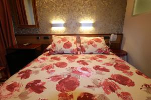 uma cama com um edredão floral e 2 almofadas em Hostal Hispano - Argentino Gran Vía em Madri