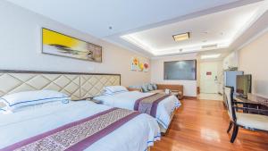 Habitación de hotel con 2 camas y TV de pantalla plana. en The Legend Nuomo Service Apartment, en Guangzhou