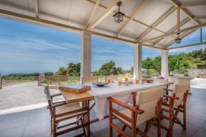 a dining room with a table and chairs and a large window at Anastasia Holiday Villa in Agalás