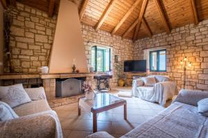 a living room with two couches and a fireplace at Anastasia Holiday Villa in Agalás