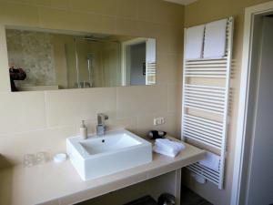 a bathroom with a white sink and a mirror at Hotel Seeblick Garni in Plön