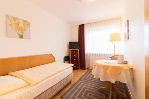 une chambre d'hôtel avec un lit et une table dans l'établissement Hotel Seeblick Garni, à Plön