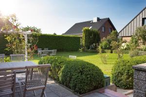 un jardín con mesa, sillas y arbustos en Hotel Seeblick Garni en Plön