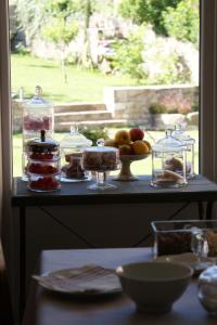 einen Tisch mit Kuchen und Obst in Glas-Gläsern in der Unterkunft Les FREJALS in Compeyre
