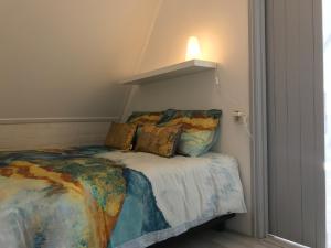 sypialnia z łóżkiem i lampką na ścianie w obiekcie Appartement Dokkum w mieście Dokkum