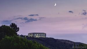 a building on a hill with the moon in the sky at Villa Crawford in San Nicola Arcella